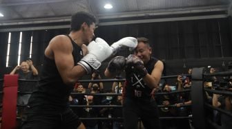 Presenter Vicky Prasetyo beradu tinju (boxing) dengan peraih medali emas PON Papua 2020 Jekson Karmela di United Gym, Cengkareng, Jakarta, Senin (14/2/2022). [Suara.com/Angga Budhiyanto]