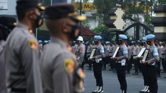 Polisi membawa foto anggota Polri yang diberhentikan saat upacara pemberhentian tidak dengan hormat (PTDH) di Polrestabes Surabaya, Jawa Timur, Senin (14/2/2022). ANTARA FOTO/Didik Suhartono
