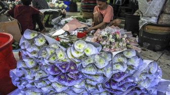 Pedagang menata buket atau karangan bunga di Pasar Bunga Rawa Belong, Jakarta, Senin (14/2/2022).  ANTARA FOTO/Reno Esnir