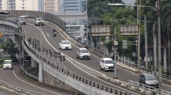 Sejumlah kendaraan melintas di Jalan Gatot Subroto, Jakarta Selatan, Selasa (15/2/2022). [Suara.com/Alfian Winanto]