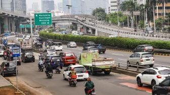 Sejumlah kendaraan melintas di Jalan Gatot Subroto, Jakarta Selatan, Selasa (15/2/2022). [Suara.com/Alfian Winanto]