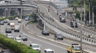 Sejumlah kendaraan melintas di Jalan Gatot Subroto, Jakarta Selatan, Selasa (15/2/2022). [Suara.com/Alfian Winanto]