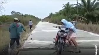 Cor-coran Jalan Masih Basah, Ibu-ibu Ini Nekat Terobos sampai Motor Terperosok