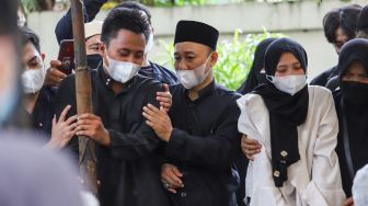 Tangis keluarga saat prosesi pemakaman Artis Dorce Gamalama di TPU Bantar Jati, Cipayung, Jakarta Timur, Rabu (16/2/2022). [Suara.com/Alfian Winanto]