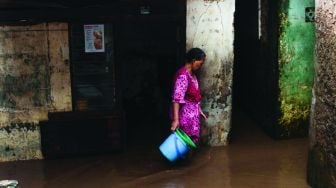 Warga permukiman kebon pala berkativitas saat banjir di Kampung Melayu, Jatinegara, Jakarta Timur, Kamis (17/2/2022). [Suara.com/Septian]