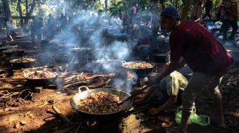 Warga bergotong royong memasak daging kambing untuk dibagikan kepada peziarah dalam tradisi Nyadran di kompleks pemakaman Sentono, Kelurahan Ngijo, Gunungpati, Semarang, Jawa Tengah, Kamis (17/2/2021). [ANTARA FOTO/Aji Styawan/rwa]