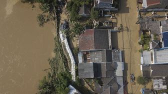 Foto udara tanggul yang rusak saat banjir di Pondok Gede Permai, Bekasi, Jawa Barat, Kamis (17/2/2022). [ANTARA FOTO/ Fakhri Hermansyah/rwa]