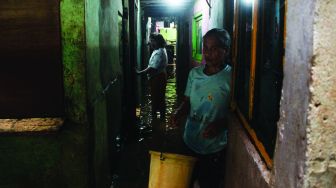 Warga permukiman kebon pala berkativitas saat banjir di Kampung Melayu, Jatinegara, Jakarta Timur, Kamis (17/2/2022). [Suara.com/Septian]