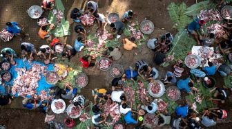 Foto udara warga bergotong royong menyortir daging kambing untuk dimasak dalam tradisi Nyadran di kompleks pemakaman Sentono, Kelurahan Ngijo, Gunungpati, Semarang, Jawa Tengah, Kamis (17/2/2021). [ANTARA FOTO/Aji Styawan/rwa]