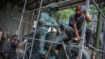 Pekerja memasang rangka untuk mengemas patung Presiden Joko Widodo yang menaiki sepeda motor di NuArt Sculpture Park, Bandung, Jawa Barat, Jumat (18/2/2022). ANTARA FOTO/Raisan Al Farisi