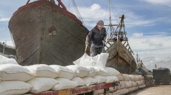 Buruh melakukan bongkar muat barang di Pelabuhan Sunda Kelapa, Jakarta Utara, Jumat (18/2/2022). [Suara.com/Alfian Winanto]