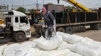 Buruh melakukan bongkar muat barang di Pelabuhan Sunda Kelapa, Jakarta Utara, Jumat (18/2/2022). [Suara.com/Alfian Winanto]