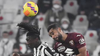 Penyerang Juventus Moise Kean (kiri) berebut bola dengan bek Koffi Djidji selama pertandingan sepak bola Serie A Italia Juventus melawan Torino di stadion Allianz, Turin, Italia, Sabtu (19/2/2022) dini hari WIB. Filippo MONTEFORTE / AFP