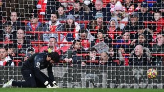 Reaksi kiper Liverpool Alisson Becker setelah gawangnya dibobol pemain tengah Norwich City Milot Rashica saat pertandingan sepak bola Liga Premier Inggris antara Liverpool dan Norwich City di Stadion Anfield, Liverpool, Inggris, Sabtu (19/2/2022). [Oli SCARFF / AFP]
