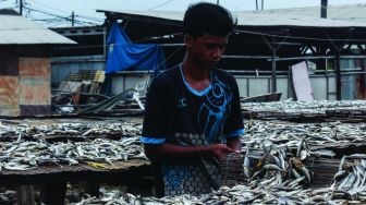 Pekerja saat mengeringkan ikan asin di Kampung Nelayan, Muara Angke, Jakarta Utara, Minggu (20/2/2022). [Suara.com/Septian]