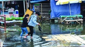 Aktivitas warga sekitar saat banjir Rob di pelabuhan Muara Angke, Jakarta Utara, Minggu (20/2/2022).  [Suara.com/Septian]