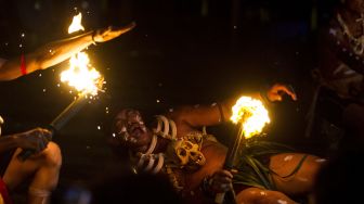 Penari melakukan atraksi api sebagai bagian Tari Atraksi Mandau Bekasai Api pada Festival Budaya Dayak Maanyan Warukin di Desa Warukin, Kabupaten Tabalong, Kalimantan Selatan, Sabtu (19/2/2022). [ANTARA FOTO/Bayu Pratama S]