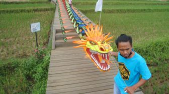 Peserta bersiap menaikkan layangan naga saat Festival Layangan di Agroeduwisata Organik Mulyaharja, Kota Bogor, Jawa Barat, Sabtu (19/2/2022). [ANTARA FOTO/Arif Firmansyah/aww]
