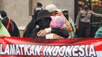 Massa yang tergabung dalam Persatuan Emak-Emak Indonesia (Permindo) menggelar unjuk rasa di depan Gedung DPR, Jakarta Pusat, Senin (21/2/2022). [Suara.com/Alfian Winanto]