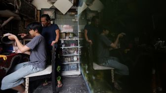 Andika Dwi Pangga (16) menyelesaikan pembuatan batik rekat pada media pot bunga di Say Galery, Sukmajaya, Depok, Jawa Barat, Senin (21/2/2021). [Suara.com/Angga Budhiyanto]