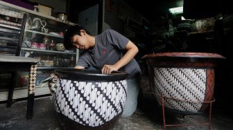 Andika Dwi Pangga (16) menyelesaikan pembuatan batik rekat pada media pot bunga di Say Galery, Sukmajaya, Depok, Jawa Barat, Senin (21/2/2021). [Suara.com/Angga Budhiyanto]