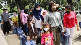 Warga Muara Angke melakukan aksi sambil membawa jeriken kosong di depan Gedung Balai Kota DKI Jakarta, Jakarta Pusat, Selasa (22/2/2022). [Suara.com/Alfian Winanto]