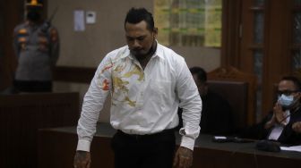 Terdakwa yang juga musisi I Gede Ari Astina atau Jerinx Superman is Dead (SID) menjalani sidang lanjutan kasus pengancaman melalui media elektronik pada Adam Deni beragendakan pleidoi atau pembacaan nota pembelaan di Pengadilan Negeri (PN) Jakarta Pusat, Jakarta, Selasa (22/2/2022). [Suara.com/Angga Budhiyanto]