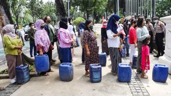 Warga Muara Angke melakukan aksi sambil membawa jeriken kosong di depan Gedung Balai Kota DKI Jakarta, Jakarta Pusat, Selasa (22/2/2022). [Suara.com/Alfian Winanto]