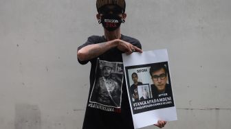 Penggemar musisi Jerinx SID dan band Superman Is Dead (SID), Outsider menggelar aksi solidaritas di Pengadilan Negeri (PN) Jakarta Pusat, Jakarta, Selasa (22/2/2022). [Suara.com/Angga Budhiyanto]