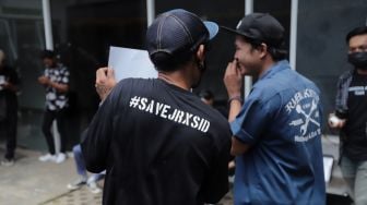 Penggemar musisi Jerinx SID dan band Superman Is Dead (SID), Outsider menggelar aksi solidaritas di Pengadilan Negeri (PN) Jakarta Pusat, Jakarta, Selasa (22/2/2022). [Suara.com/Angga Budhiyanto]