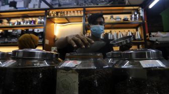 Pramuniaga melayani pembeli biji kopi di Toko Dunia Kopi, Pasar Santa, Jakarta, Rabu (23/2/2022). [Suara.com/Angga Budhiyanto]