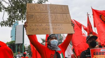 Massa buruh saat menggelar aksi unjuk rasa di depan gedung Kementerian Tenaga Kerja (Kemenaker) di Setia Budi, Jakarta Selatan, Rabu (23/2/2022). [Suara.com/Alfian Winanto]