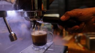 Barista meracik kopi di Toko Dunia Kopi, Pasar Santa, Jakarta, Rabu (23/2/2022). [Suara.com/Angga Budhiyanto]