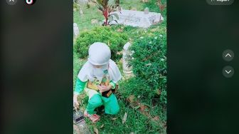 Bikin Mata Berkaca-kaca! Viral Bocah Susun Piala yang Ia Dapatkan di Makam Sang Ayah Sambil Berdoa