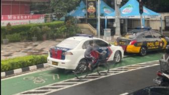 Viral Dua Mobil Dinas Polisi Parkir Di Jalur Sepeda Bundaran HI, Warganet: Mengambil Yang Bukan Haknya