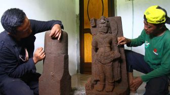 Arkeolog dari tim Balai Pelestarian Cagar Budaya (BPCB) Trowulan menyatukan bagian arca Agastya yang ditemukan saat eskavasi tahap kedua di situs Srigading, Lawang, Malang, Jawa Timur, Rabu (23/2/2022).  ANTARA FOTO/Ari Bowo Sucipto

