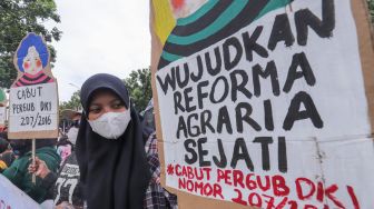 Massa yang tergabung dalam Koalisi Rakyat Menolak Penggusuran (KRMP) menggelar aksi di depan Balai Kota DKI Jakarta, Jakarta Pusat, Kamis (24/2/2022). [Suara.com/Alfian Winanto]