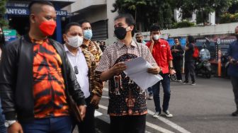 Mantan Menteri Pemuda dan Olahraga (Menpora) Roy Suryo usai mendatangi gedung SPKT di Polda Metro Jaya, Jakarta Selatan, Kamis (24/2/2022). [Suara.com/Alfian Winanto]