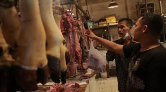 Penjual daging sapi melayani pembeli di salah satu los daging di Pasar Senen, Jakarta, Sabtu (26/2/2022). [Suara.com/Angga Budhiyanto]