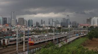 Rangkaian KRL Commuter Line melintas di dekat permukiman padat penduduk di kawasan Tanah Abang, Jakarta, Sabtu (26/2/2022). [Suara.com/Angga Budhiyanto]