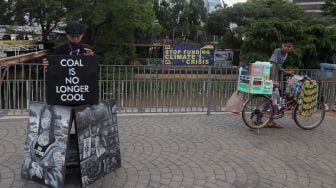 Seniman melakukan aksi pameran seni jalanan atau 'street art' di kawasan Dukuh Atas, Jakarta, Sabtu (26/2/2022). [Suara.com/Angga Budhiyanto]