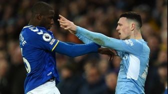 Gelandang Everton Abdoulaye Doucoure (kiri) dan gelandang Manchester City Phil Foden (kanan) saling dorong saat pertandingan sepak bola Liga Premier Inggris antara Everton dan Manchester City di Stadion Goodison Park, Inggris, Sabtu (26/2/2022). [Oli SCARFF / AFP]