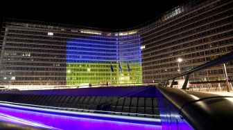 Pemandangan gedung komisi Eropa yang diterangi dengan warna bendera Ukrania selama berlangsungnya KTT darurat tentang krisis Rusia - Ukraina di markas besar Uni Eropa di Brussels, Belgia, Kamis (24/2/2022). [John THYS / AFP]