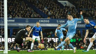  Gelandang Manchester City Phil Foden mencetak gol pertama timnya saat pertandingan sepak bola Liga Premier Inggris antara Everton dan Manchester City di Stadion Goodison Park, Inggris, Sabtu (26/2/2022). [Oli SCARFF / AFP]