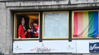 Orang-orang bersuka ria saat menghadiri acara musim Karnaval di Cologne, Jerman barat, Kamis (24/2/2022). [Ina Fassbender / AFP]