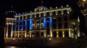  Gedung Kementerian Luar Negeri Makedonia Utara yang diterangi warna bendera Ukraina di Skopje, Makedonia utara, Kamis (24/2/2022). [Robert ATANASOVSKI / AFP]
