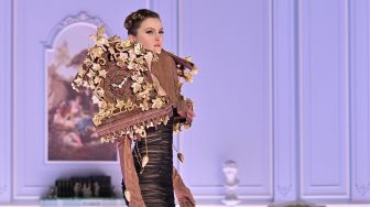 Seorang model menampilkan busana kreasi brand Moschino untuk koleksi Musim Gugur/Musim Dingin 2022/2023 di hari ketiga Milan Fashion Week di Milan, Italia, Kamis (24/2/2022). [MIGUEL MEDINA / AFP]
