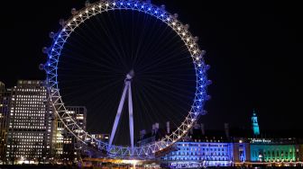 Warna bendera Ukraina ditampilkan di tempat observasi 'London Eye' di London, Inggris, Jumat (25/2/2022). [Tolga Akmen / AFP]