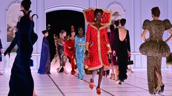 Seorang model menampilkan busana kreasi brand Moschino untuk koleksi Musim Gugur/Musim Dingin 2022/2023 di hari ketiga Milan Fashion Week di Milan, Italia, Kamis (24/2/2022). [MIGUEL MEDINA / AFP]
