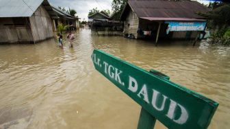 Sejumlah anak berada di tengah banjir yang melanda Desa Meunasah Joek, Lhoksukon, Aceh Utara, Aceh, Senin (28/2/2022). [ANTARA FOTO/Rahmad/tom]